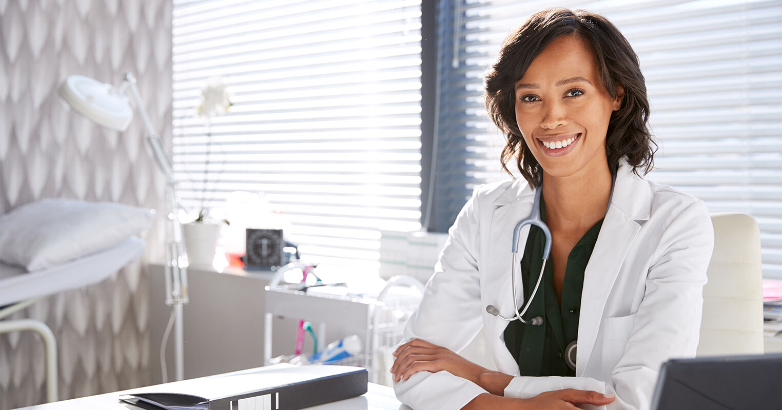 Dermatologist_smiling_while_sitting_in_office_during_a_sunny_day